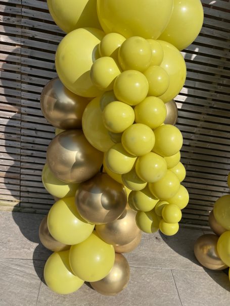 A cluster of yellow and gold balloons shaped like a bunch of grapes.