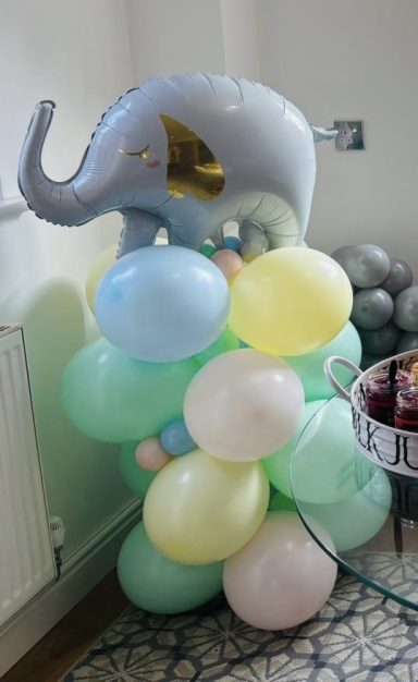 A grey elephant balloon sits atop a cluster of colourful balloons.