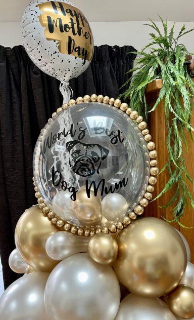 Gold and silver balloons with a decorative round balloon saying "It's a Boy!"